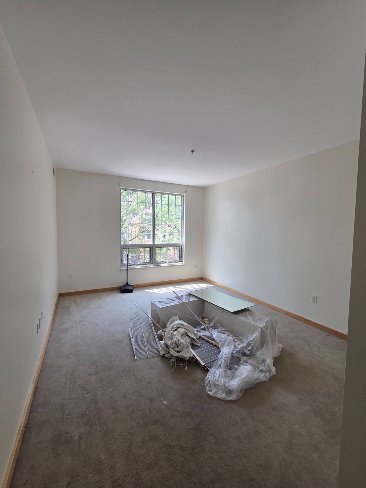 Remaining furniture pulled to the center of the room and sealed under plastic sheeting, floors covered, before painting begins