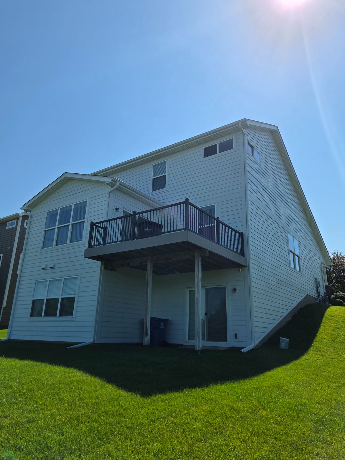 Rear of a home with a finished elevated deck and freshly painted siding